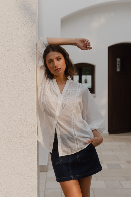women wears a white blouse with dark blue denim skirt