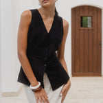 Woman wearing a black sleeveless vest on a white background