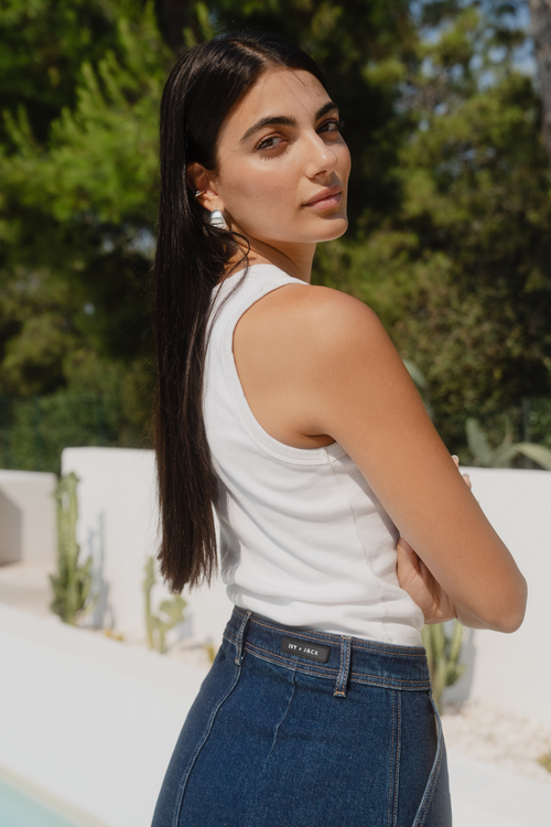 model wearing denim skirt and white tank in the sun