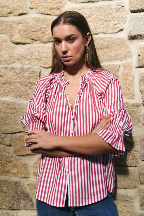 Woman wearing a red and white striped top and blue jeans
