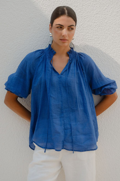 Woman wearing a blue top and white pants