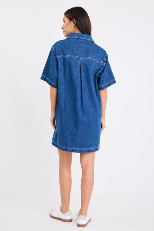 model wears a blue denim mini dress