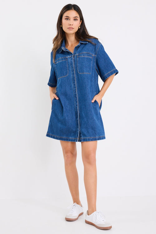 model wears a blue denim mini dress