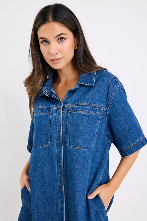 model wears a blue denim mini dress