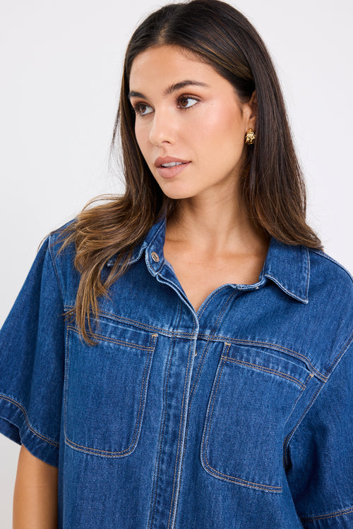 model wears a blue denim mini dress