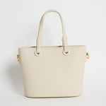 Beige PU leather mini handbag with knotted top handles and a long detachable shoulder strap, photographed against a plain light background.