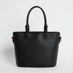 Small black PU leather handbag with knotted top handles and a long detachable shoulder strap, photographed against a plain light background