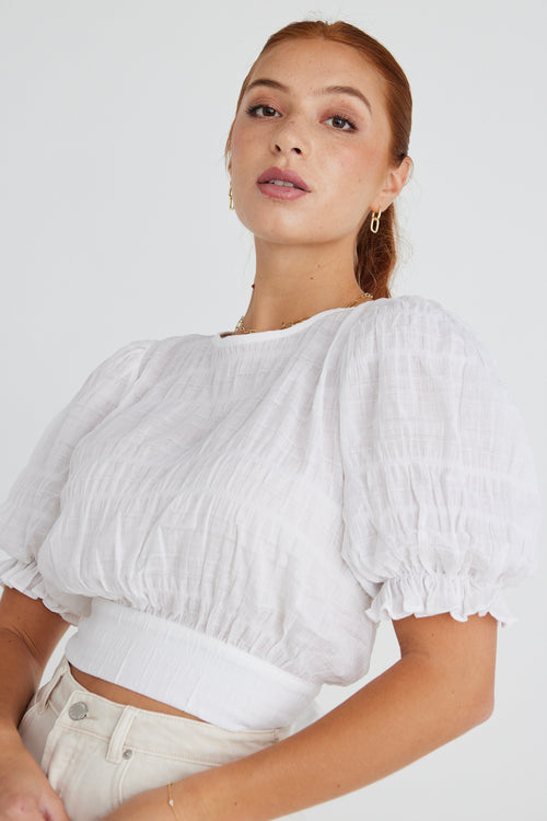 model wears a white shirred cotton top.