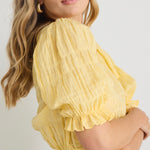 model wears a yellow puff sleeve top