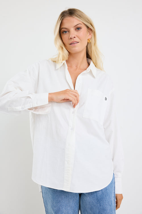 model wears a white shirt with blue jeans