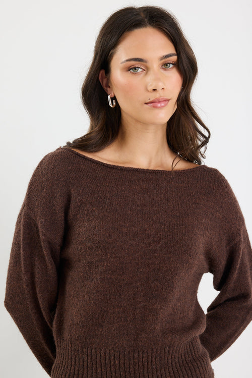 Woman wearing a brown sweater against a white background