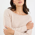 Woman wearing a beige sweater against a white background