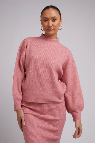 Model wears a Pink Knit with a pink skirt