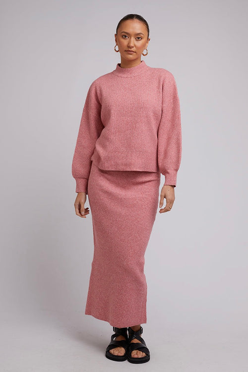 Model wears a Pink Knit with a pink skirt