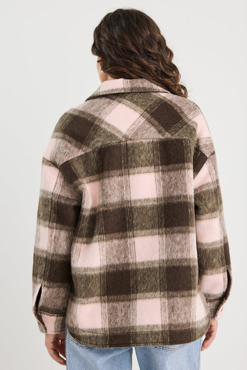 Person wearing a plaid shirt with a neutral color palette on a white background
col_pattern