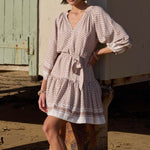 model wears a beige pattern smock mini dress