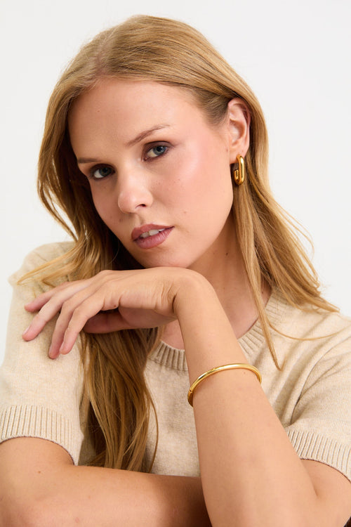 woman wearing a gold bangle 