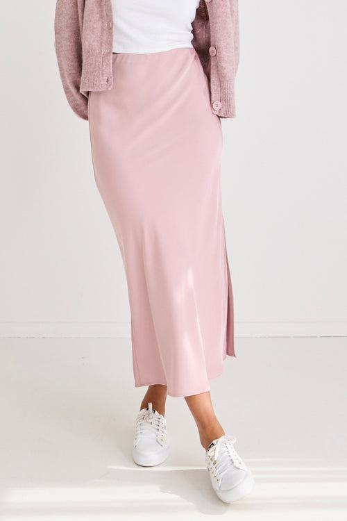 model wears a pink satin maxi skirt