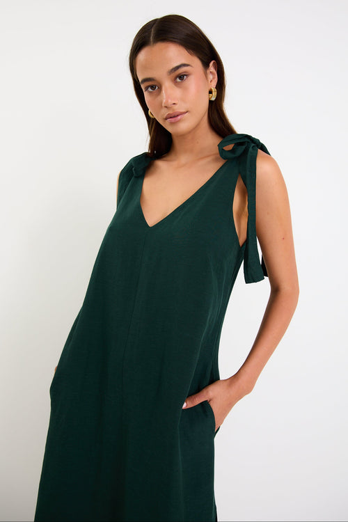 Model wearing a forest-green tie-shoulder midi dress with a relaxed fit and flowy skirt