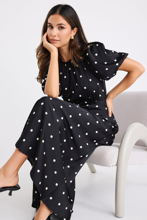 model wears a short puff sleeve black polka dot maxi dress