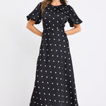 model wears a short puff sleeve black polka dot maxi dress