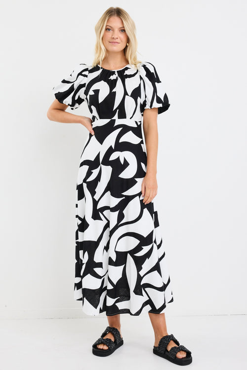 model wears a black and white floral puff sleeve maxi dress