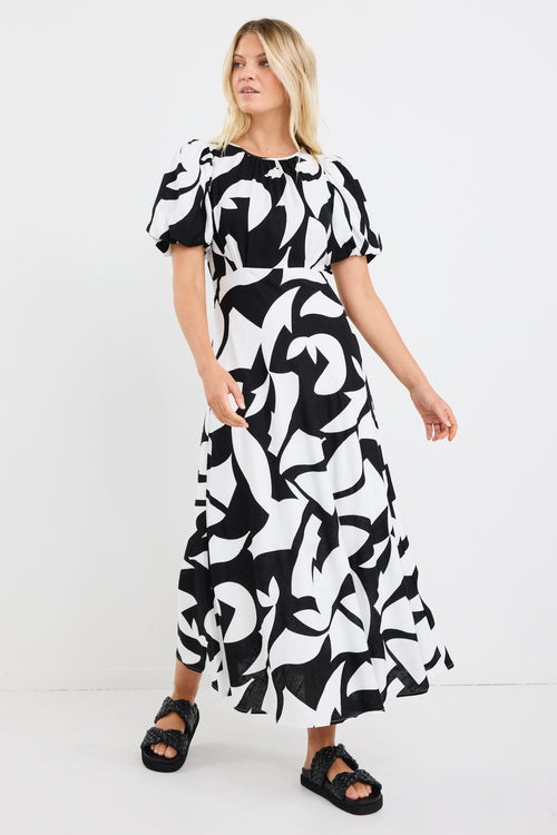 model wears a black and white floral puff sleeve maxi dress