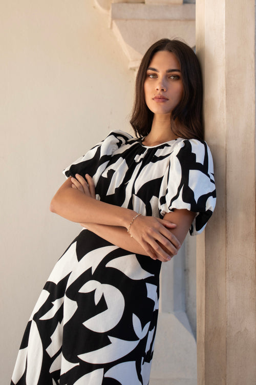 model wears a black and white floral puff sleeve maxi dress
