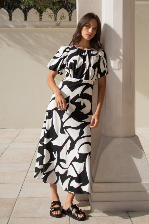 model wears a black and white floral puff sleeve maxi dress