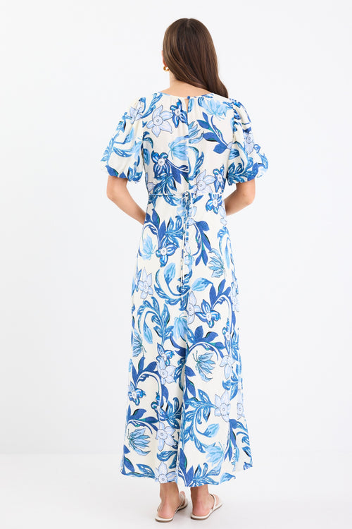 A short-sleeve floral dress with puff sleeves and a bias-cut design. The dress features a blue floral print on a cream background and is fully lined for comfort.