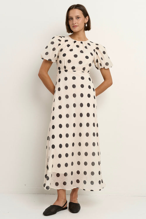 model wears a cream puff sleeve polka dot maxi dress