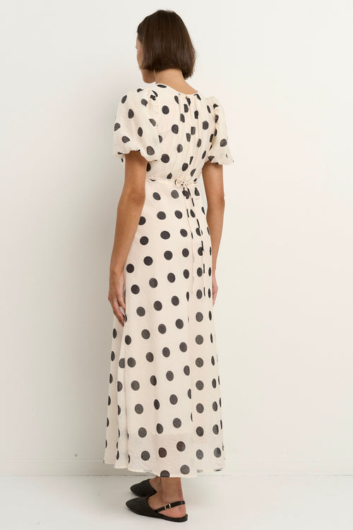 model wears a cream puff sleeve polka dot maxi dress