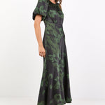 Woman wearing a green floral dress on a white background
