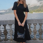 model wears a black midi dress