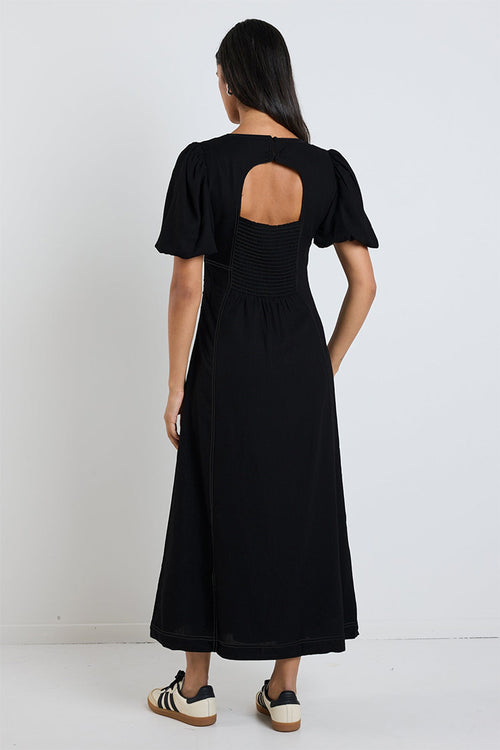 model wears a black midi dress