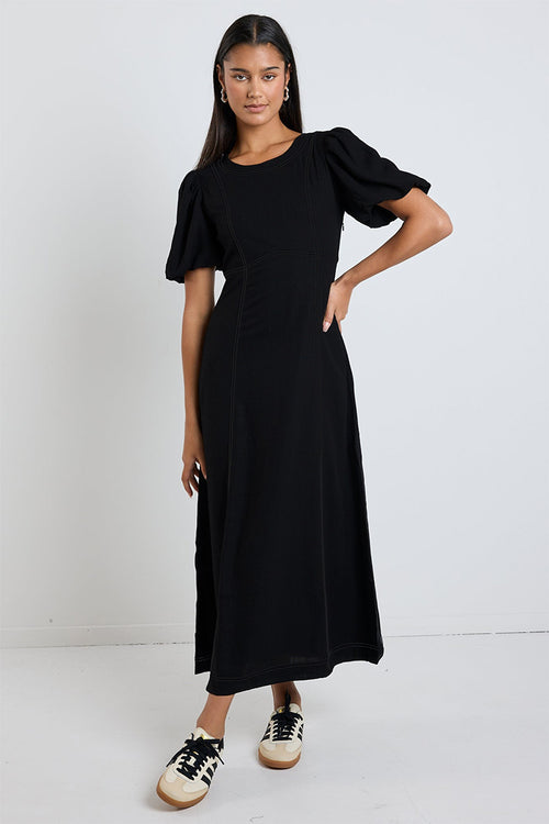 model wears a black midi dress