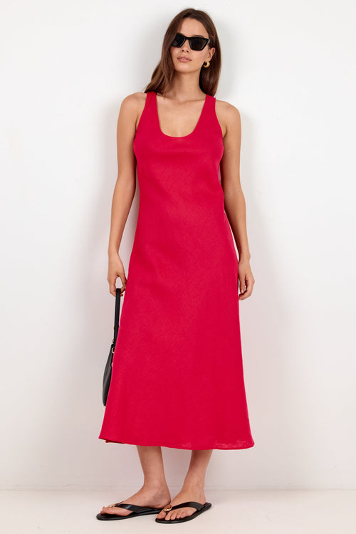 A woman modeling a sleeveless, scoop-neck maxi dress in a vibrant red color, styled with black sunglasses, black sandals, and a small black shoulder bag against a plain white studio background.