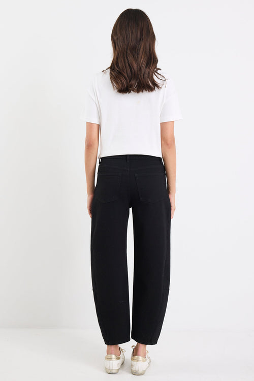 Person wearing a white top and black pants on a white background