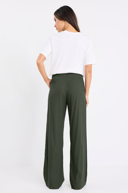 model wears a khaki linen pant with a white t-shirt
