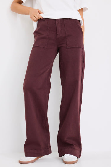model wears a burgundy jean with white t-shirt