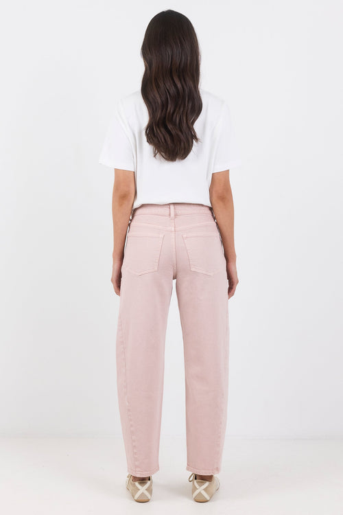 Person wearing pink pants and a white top on a white background