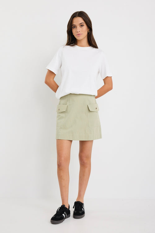 Woman wearing mid-rise chocolate zebra print shorts with an elastic waistband, styled casually with a black top and black sandals.