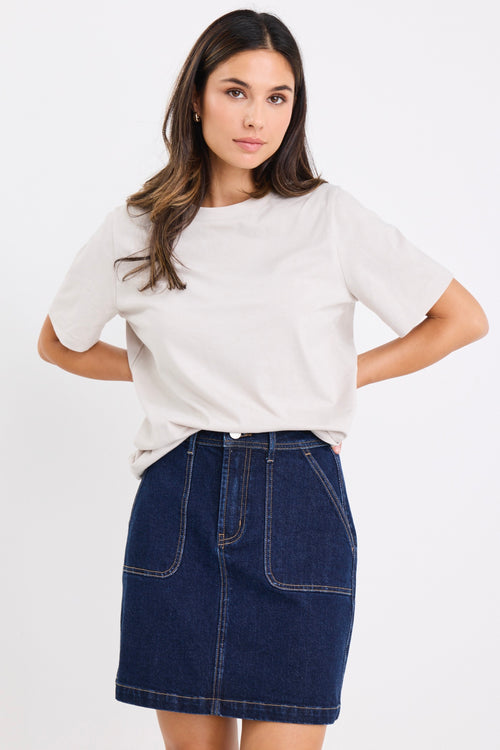 model wears a dark blue denim mini skirt