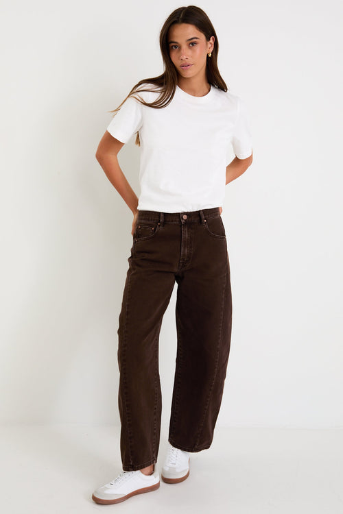 Person wearing a white t-shirt and brown pants on a white background