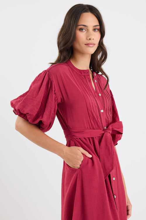 Woman wearing a red dress with puff sleeves on a white background