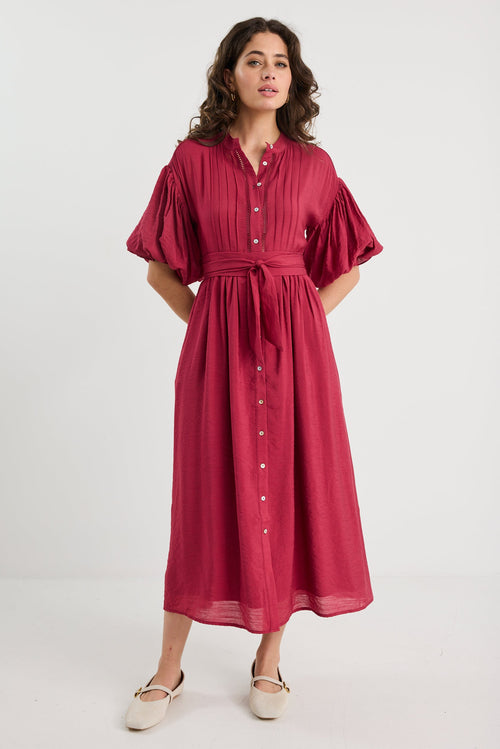 Woman wearing a red dress with puff sleeves on a white background