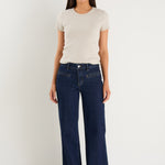 model wearing dark denim jean and white top 