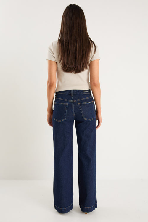 model wearing dark denim jean and white top 