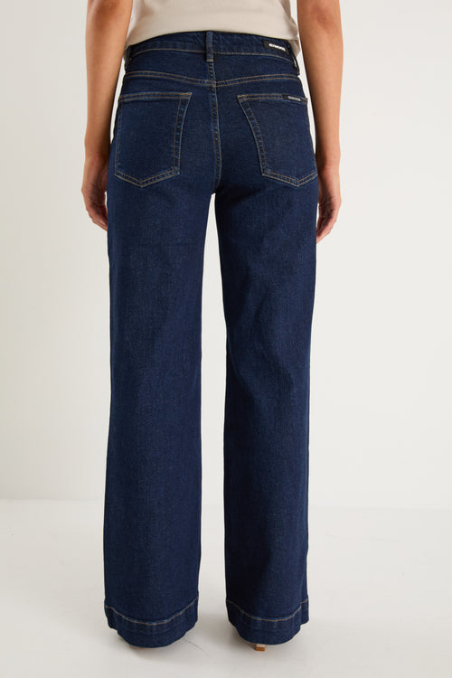 model wearing dark denim jean and white top 