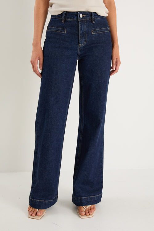 model wearing dark denim jean and white top 